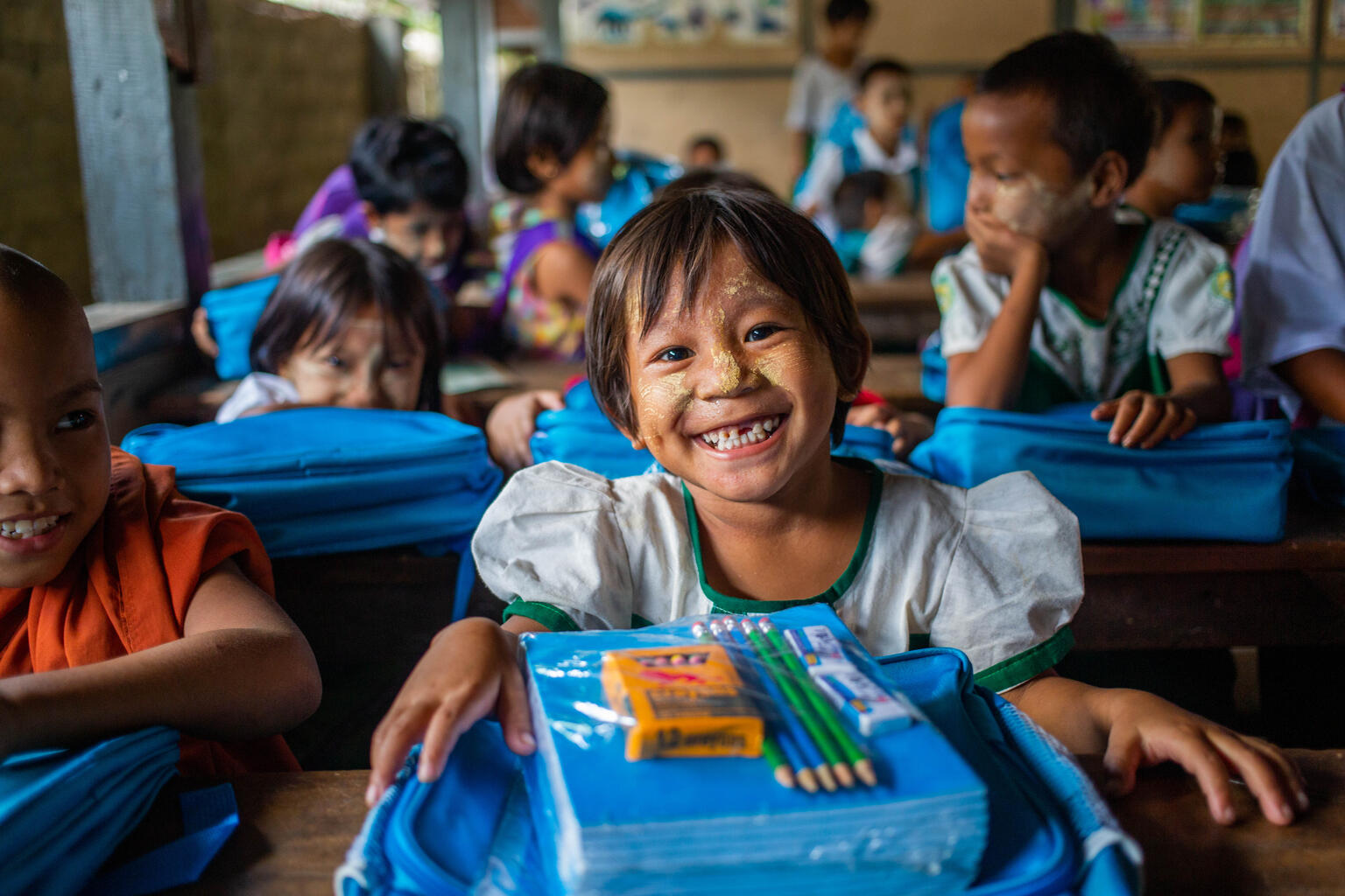 Young child in a school setting smiling at the camera